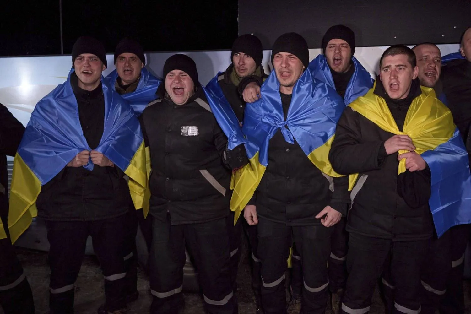 
Ukrainian prisoners of war celebrate wearing Ukrainian flags upon their return to their homeland during a prisoner exchange with Russia on February 8, 2024 (dpa)
