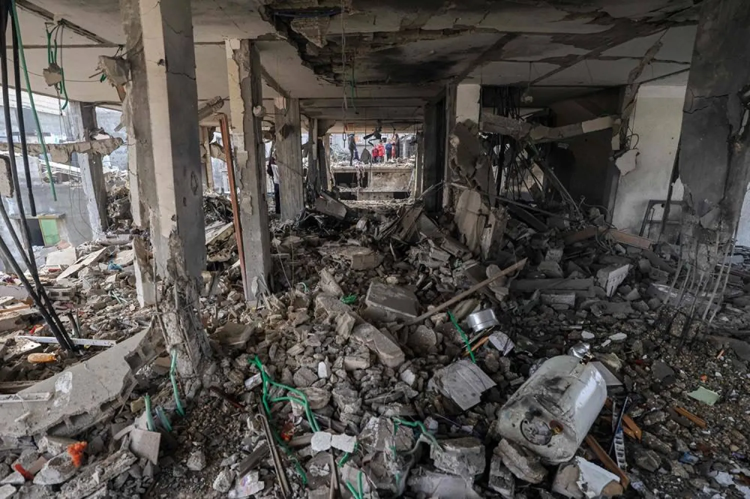  People assess the damage caused by Israeli bombardment in Rafah in the southern Gaza Strip on February 9, 2024, as battles continue between Israel and the Palestinian Hamas movement. (AFP)