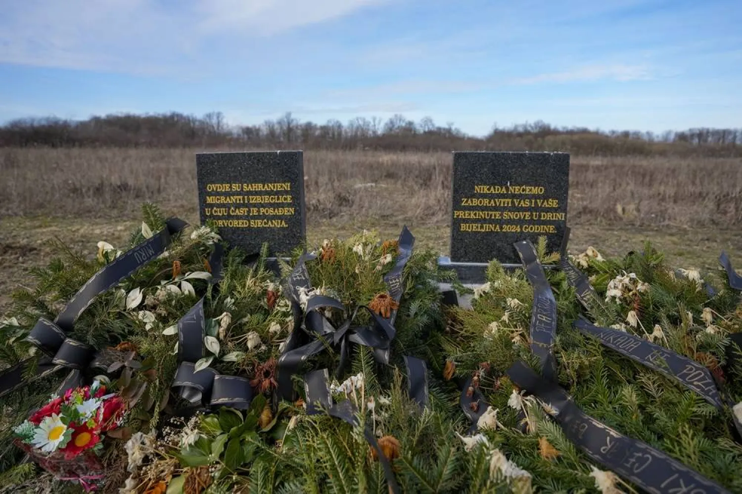 The memorial with an inscription that reads: "Migrants and refugees in whose memory these trees were planted are buried here; we will never forget you and your dreams interrupted in the Drina" is seen at the cemetery in Bijeljina, eastern Bosnia, Sunday, Feb. 4, 2024. (AP)