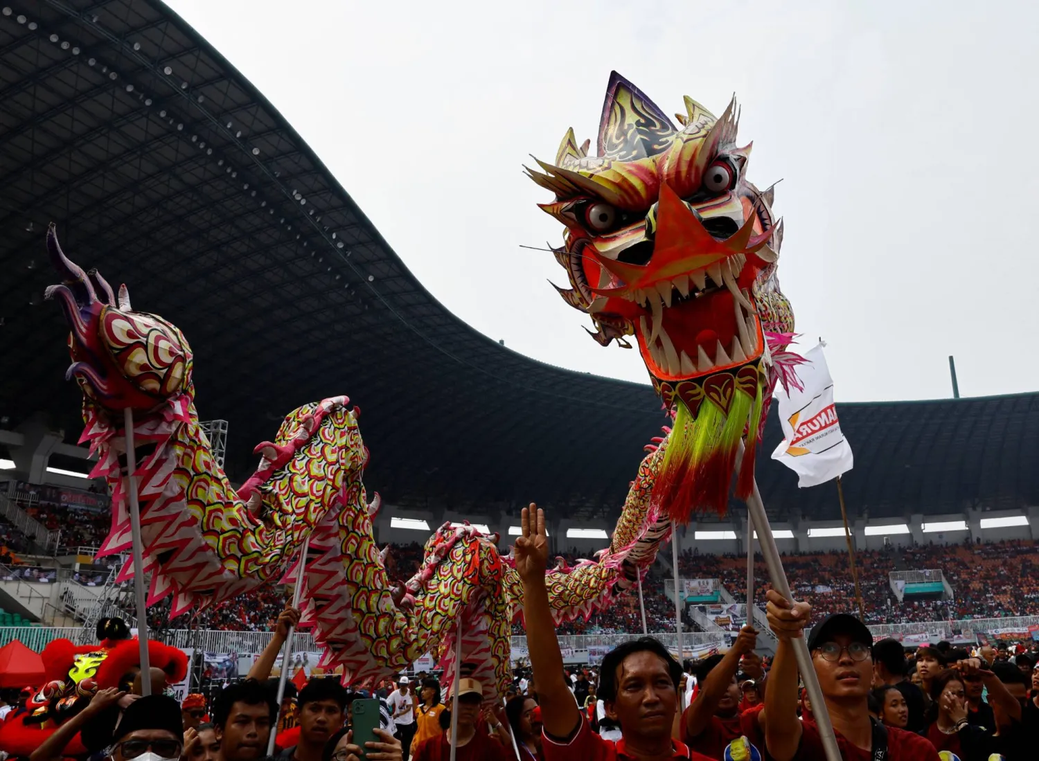 أشخاص يؤدون رقصة التنين قبل حلول العام القمري الصيني الجديد (رويترز)