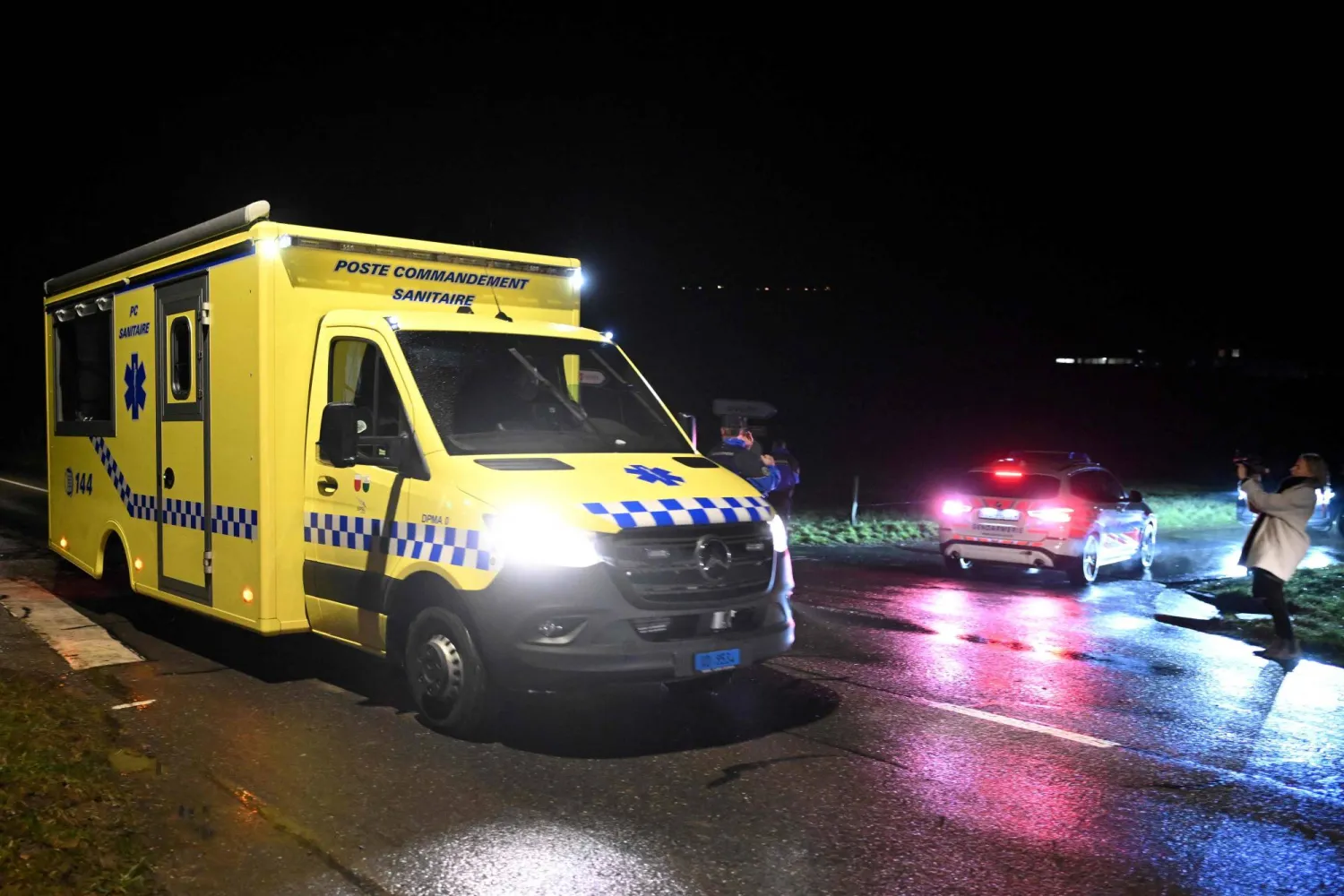 سيارة إسعاف تمر عبر طريق أغلقته قوات الدرك السويسرية المؤدية إلى محطة قطار في إيسر-سوس-شامبفينت، غرب سويسرا الخميس (أ.ف.ب)