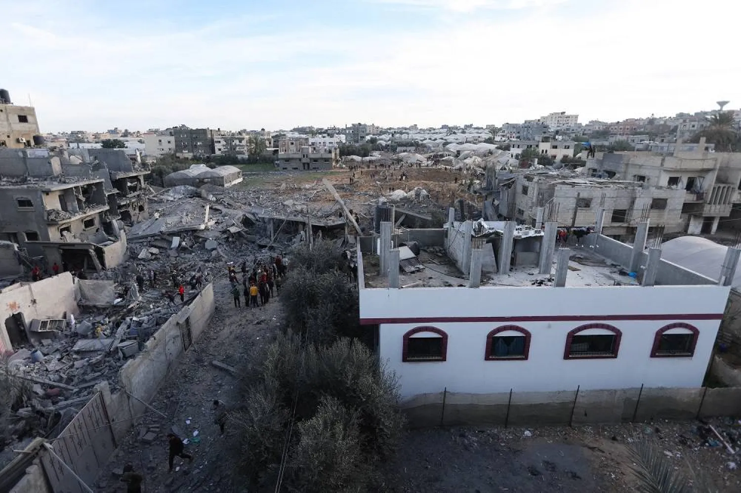 Palestinians gather at the site of an Israeli strike on a house, amid the ongoing conflict between Israel and the Palestinian group Hamas, in Rafah in the southern Gaza Strip, February 12, 2024. (Reuters)