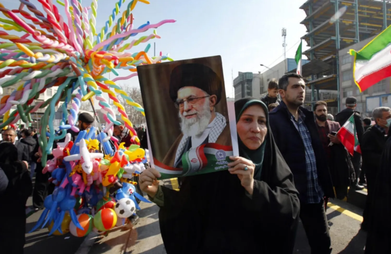 A woman raises a portrait of Iran's Supreme Leader Ayatollah Ali Khamenei, as people gather to mark the 45th anniversary of the Islamic revolution in Tehran on February 11, 2024 (AFP)