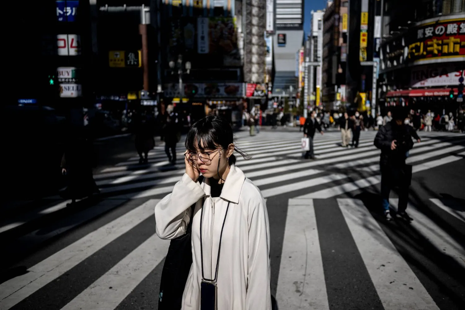 Pedestrians walk in Shinjuku district of Tokyo on February 13, 2024. (Photo by Philip FONG / AFP)