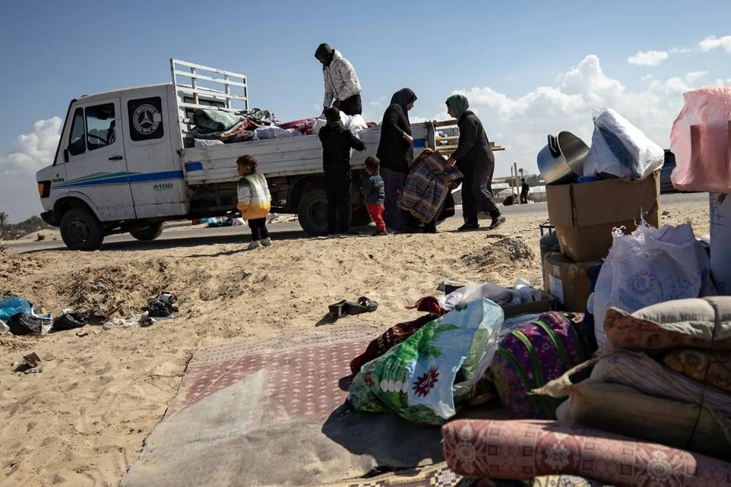 Displaced Palestinians from the Al-Bilbisi family collect their belongings to leave the Rafah camp in the southern Gaza Strip, heading towards the central part of it, after the Israeli army announced upcoming launch of a military operation inside Rafah, 14 February 2024. (EPA)