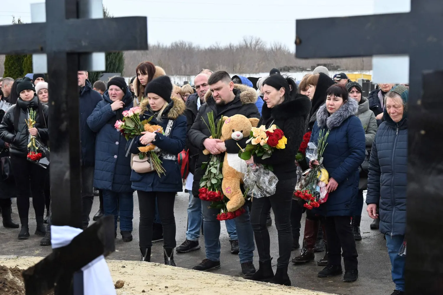 أقارب في دفن عائلة من 5 أشخاص بينهم 3 أطفال لقوا حتفهم بحريق منزلهم بعد هجوم بطائرة روسية مسيّرة على محطة بنزين في خاركيف يوم 12 فبراير 2024 وسط الغزو الروسي لأوكرانيا (أ.ف.ب)