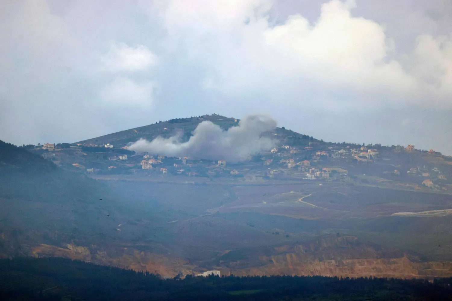 صورة ملتقطة من موقع إسرائيلي على طول الحدود مع جنوب لبنان تُظهر الدخان يتصاعد فوق قرية العديسة اللبنانية أثناء القصف الإسرائيلي في 18 فبراير 2024 (أ.ف.ب)