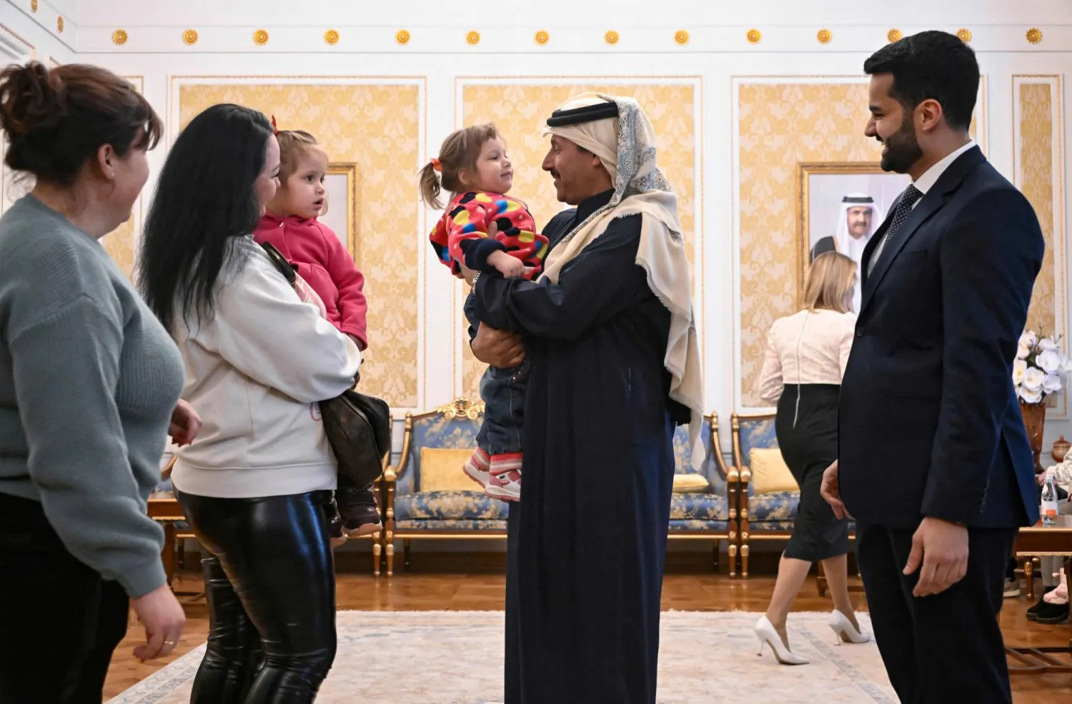 سفير قطر لدى روسيا الشيخ أحمد بن ناصر آل ثاني يتفاعل مع الأطفال الأوكرانيين قبل مغادرتهم إلى بلادهم في مقر السفارة القطرية بموسكو الاثنين (أ.ف.ب)
