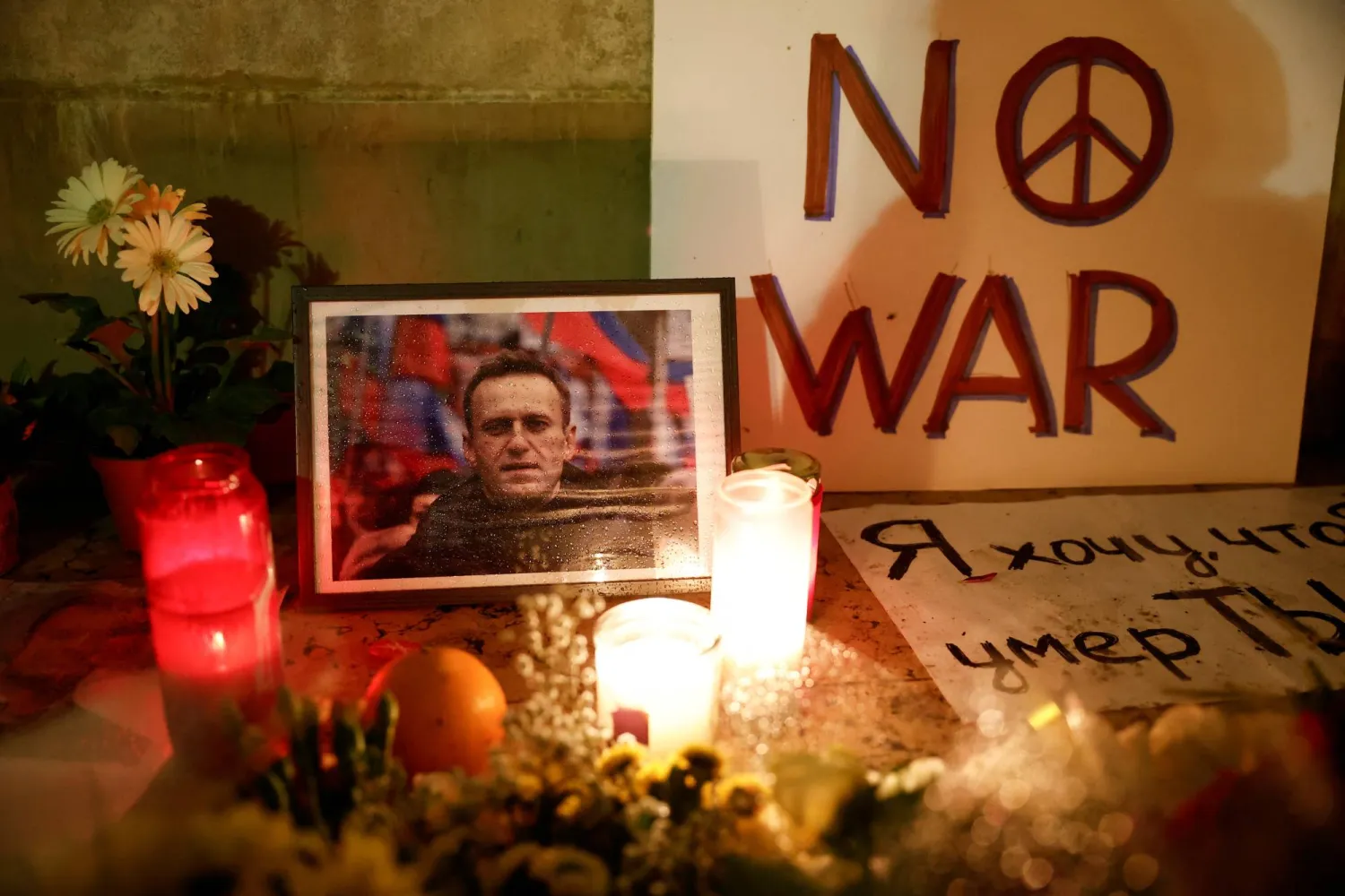 شموع وصور للمعارض الروسي  أليكسي نافالني خلال وقفة احتجاجية  في تروكاديرو بالقرب من برج إيفل في باريس عقب وفاته (رويترز)