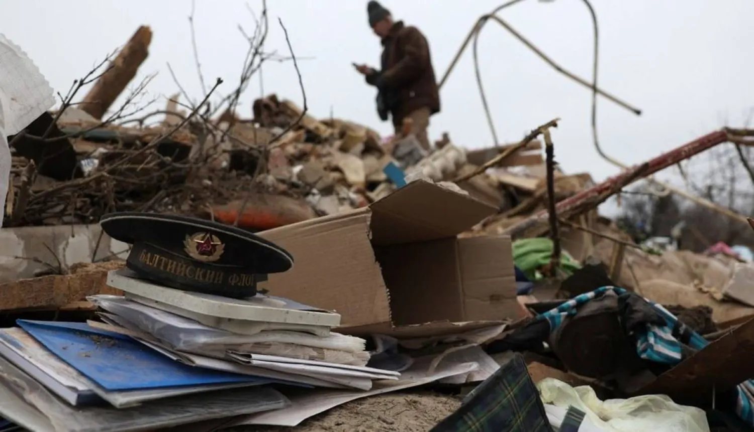 أقارب يبحثون عن متعلقات شخصية لعائلة متوفاة وسط أنقاض منزل دمره هجوم صاروخي في بلدة كراماتورسك وسط الغزو الروسي لأوكرانيا (أ.ف.ب)