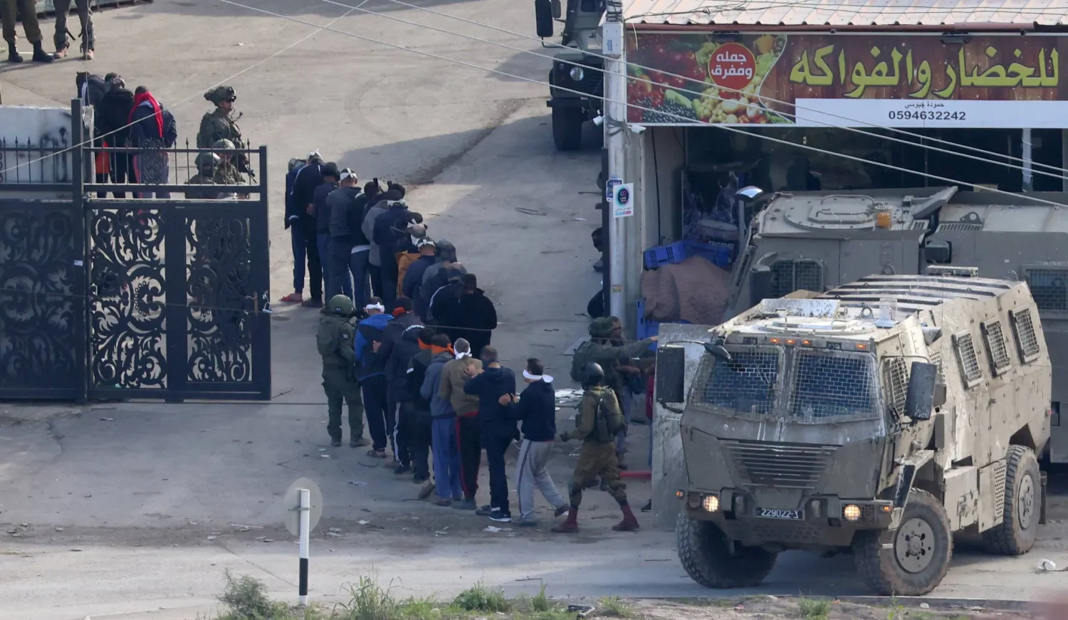 فلسطينيون أوقفهم جنود إسرائيليون خلال عملية عسكرية في مخيم «نور شمس» للاجئين قرب مدينة طولكرم بالضفة الغربية 3 يناير (إ.ب.أ)