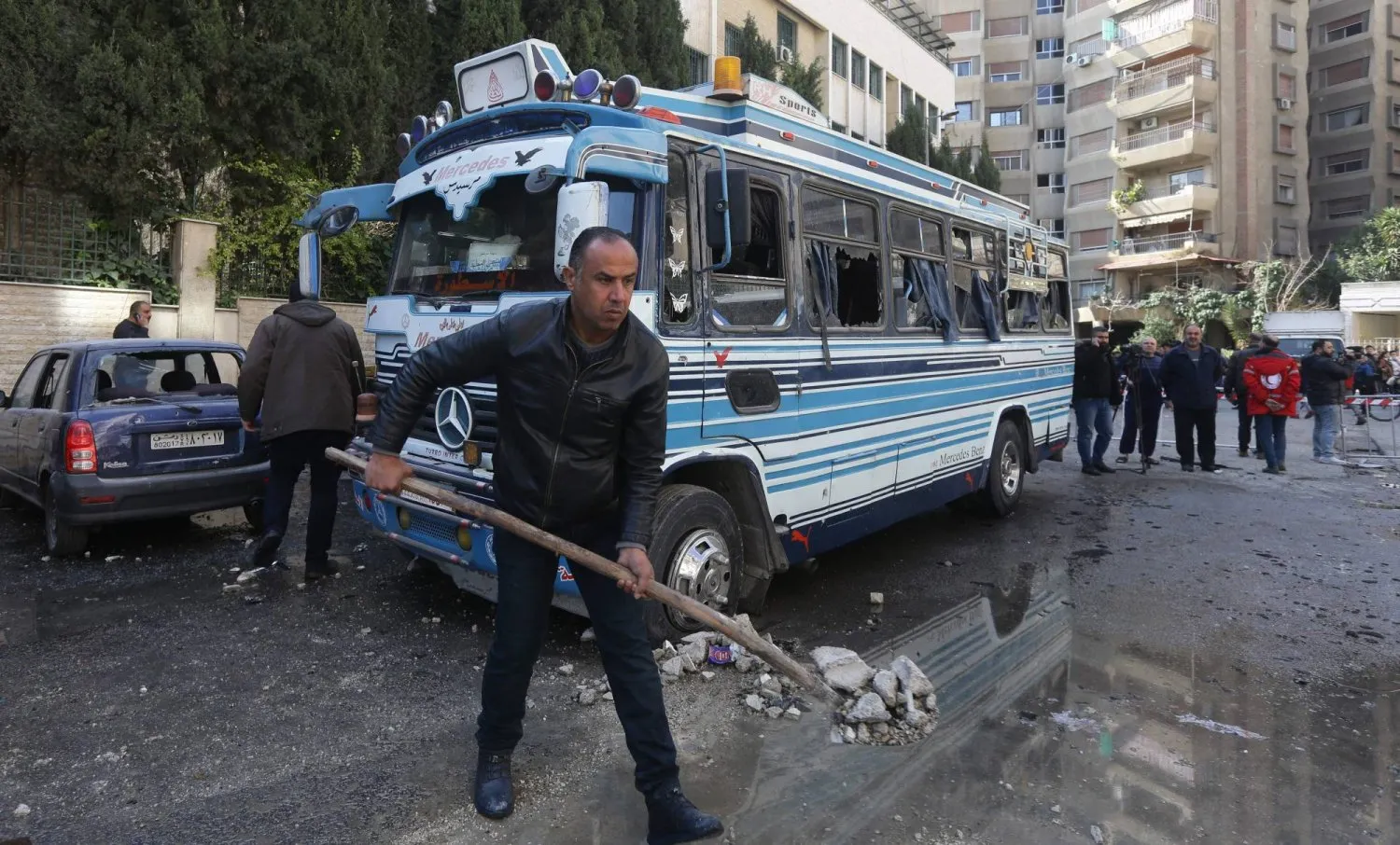 İsrail hava saldırılarının Şam'ın Kafr Sousa mahallesindeki bir apartmanı hedef aldığı bölgedeki molozlar kaldırılıyor. (AFP)