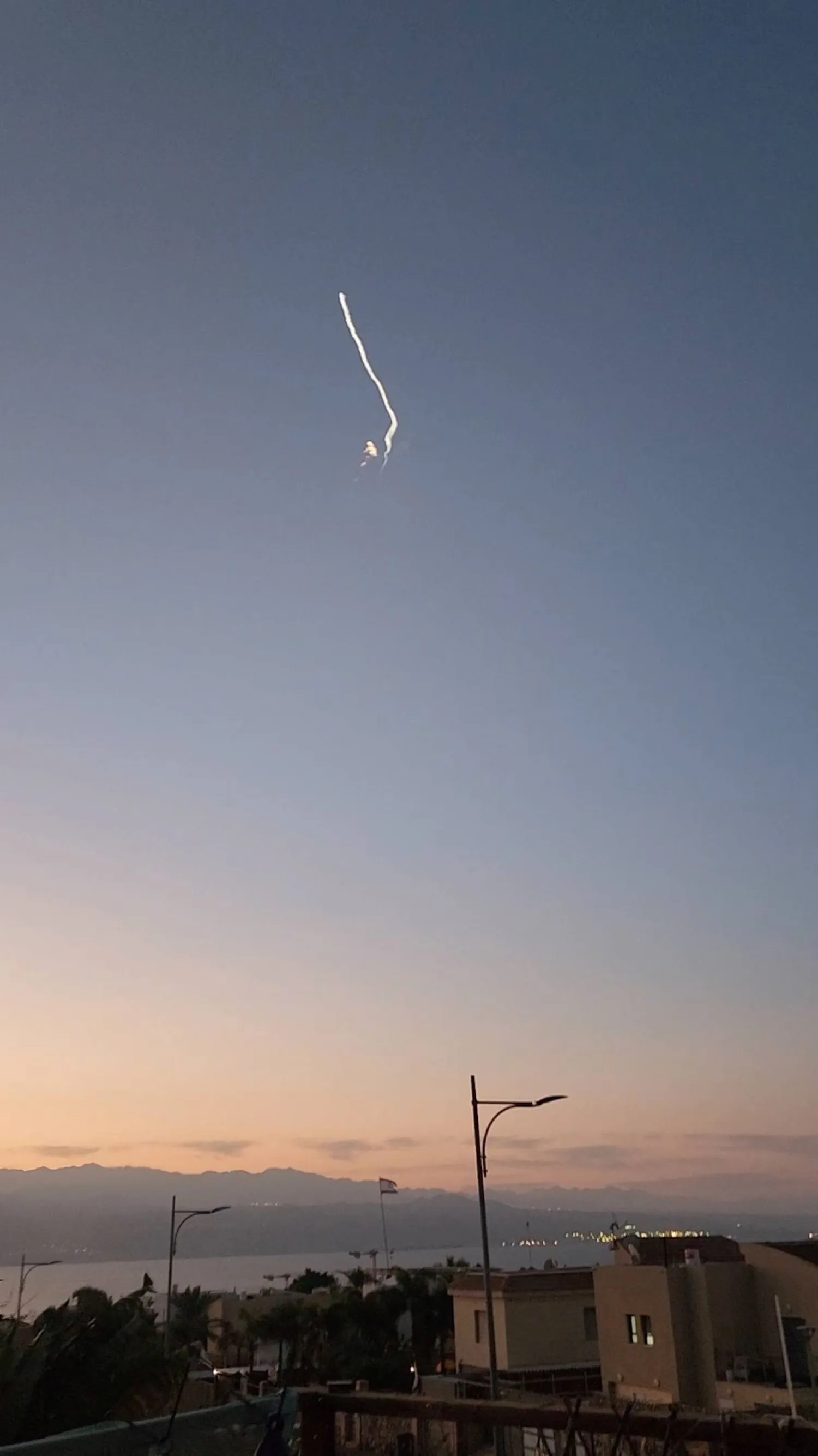A trail of white smoke in the air from what the Israeli military said was an intercepted target is pictured in Eilat, Israel February 22, 2024, in this screengrab taken from a social media video. Ronit Zilberstein/via REUTERS 