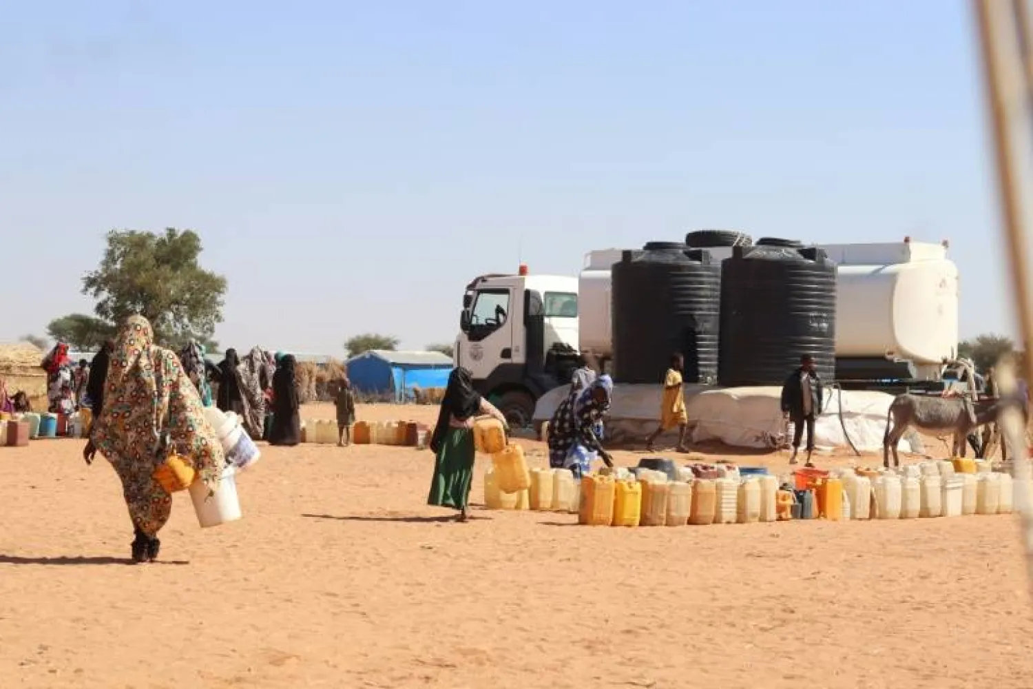 Refugees fleeing the conflict in Sudan queue to collect drinking water from the Doctors Without Borders (MSF) distribution point at Ourang refugee camp in Adre, Chad on December 7, 2023 - AFP
