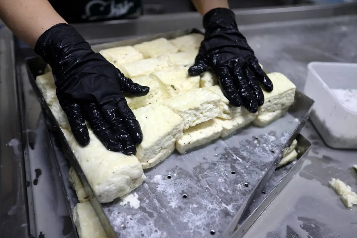 A worker prepares halloumi on Pantelis Panteli's farm in Kokkinotrimithia, Cyprus February 10, 2024. (Reuters)