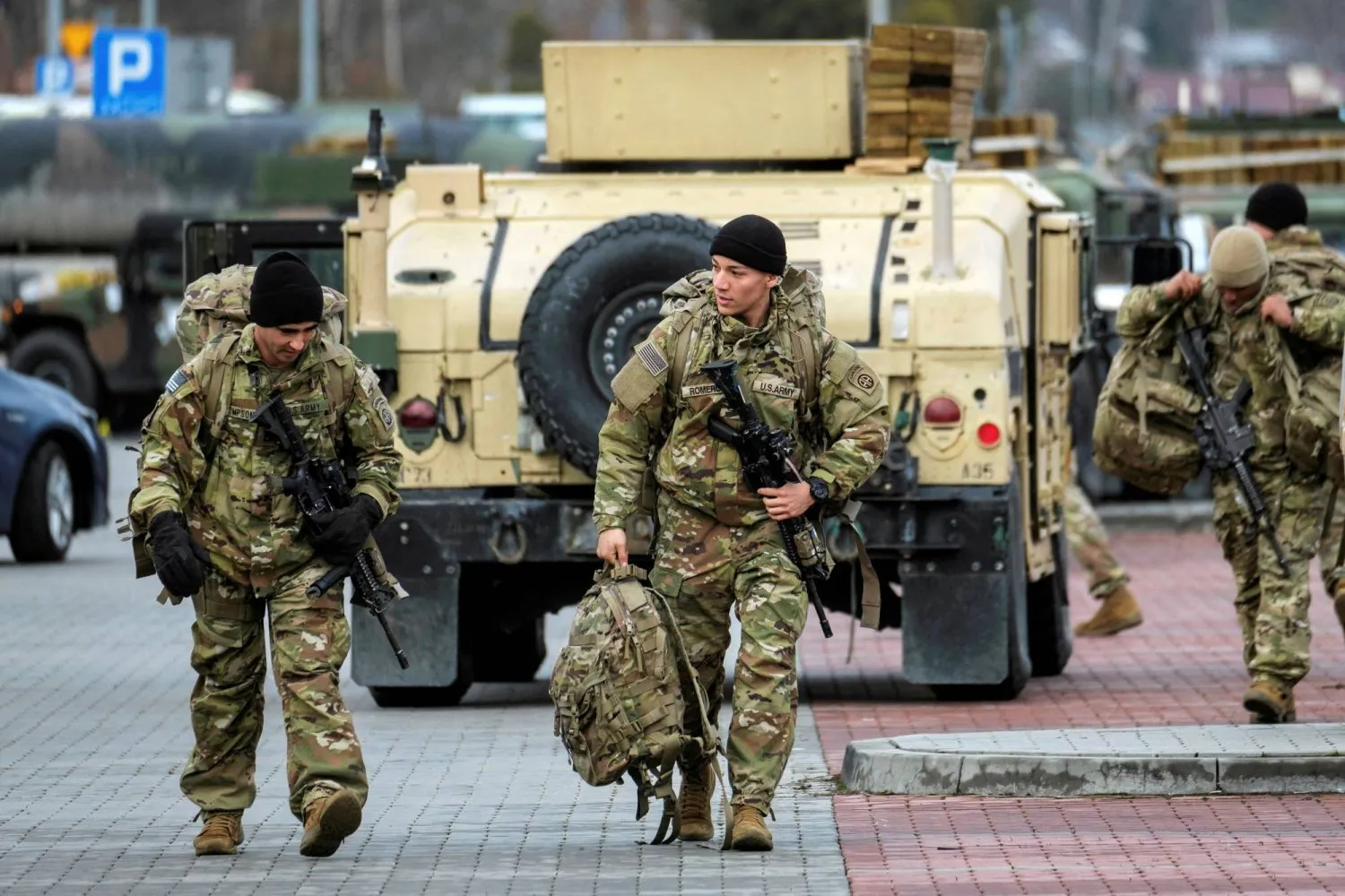 Amerikan askerleri askeri bir aracın yanında yürüyor (Reuters)