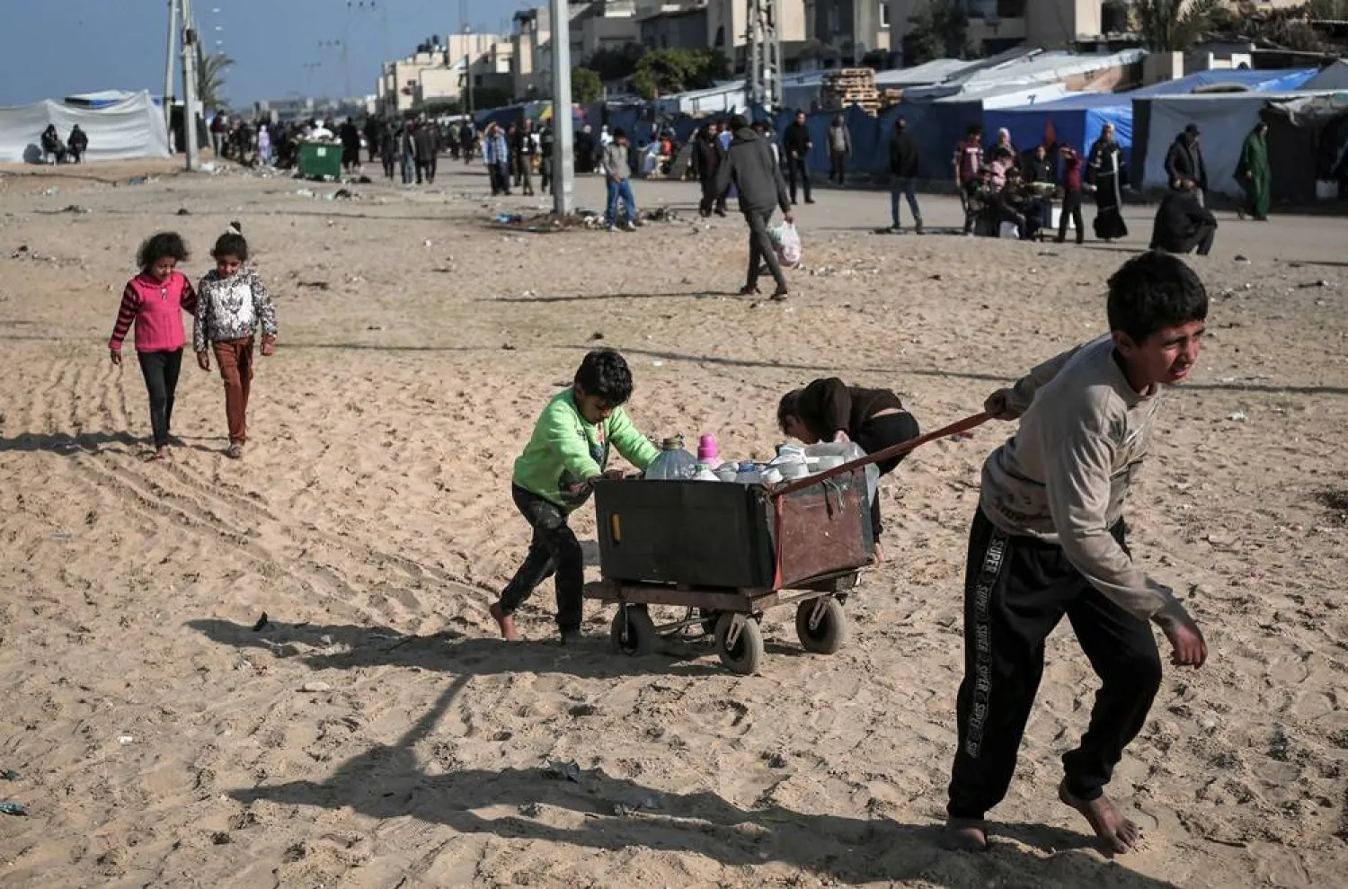  Children push a cart filled with water containers near a camp for internally displaced Palestinians in Rafah, on the southern Gaza Strip on February 28, 2024, amid ongoing battles between Israel and the militant group Hamas. (AFP)