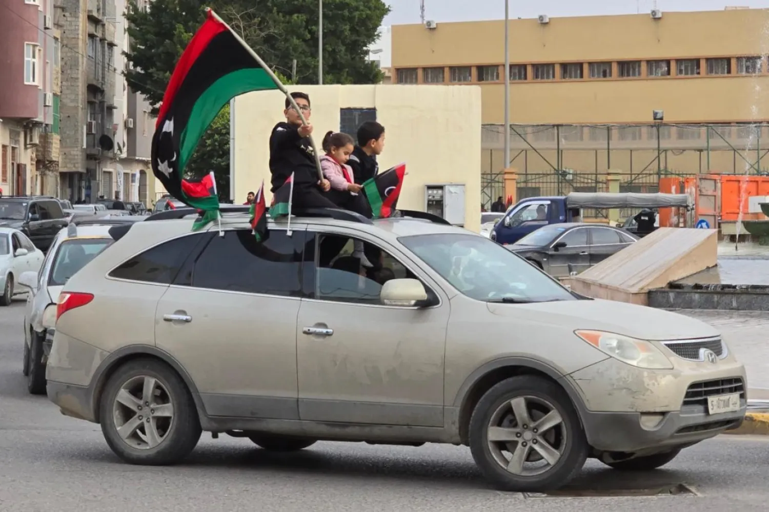 Başkent Trablus'ta bir sokakta ülkesinin bayrağını sallayan Libyalı bir çocuk. (AFP)
