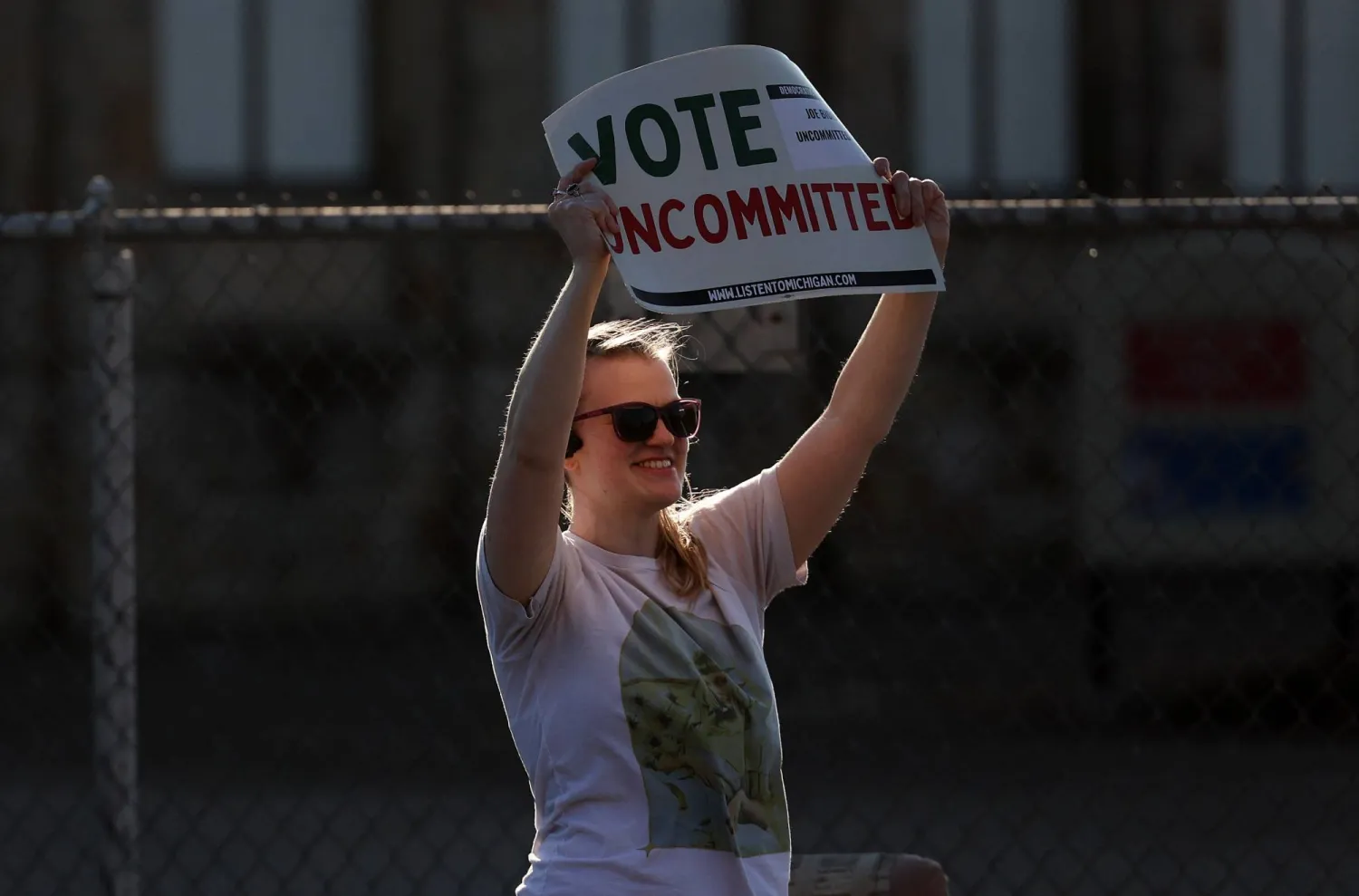 ناخبة ديمقراطية في ميشيغان تحمل لافتة تدعو إلى عدم الالتزام بالتصويت لبايدن في 27 فبراير 2024 (أ.ف.ب)