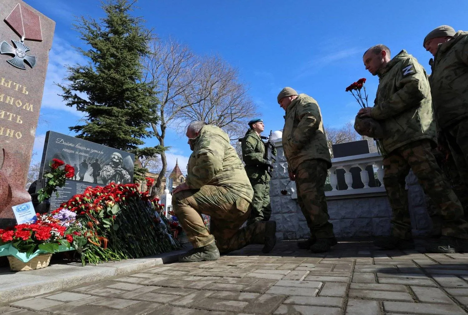 Russian soldiers near the tombs of fellow soldiers who died in the war in Crimea (Reuters)