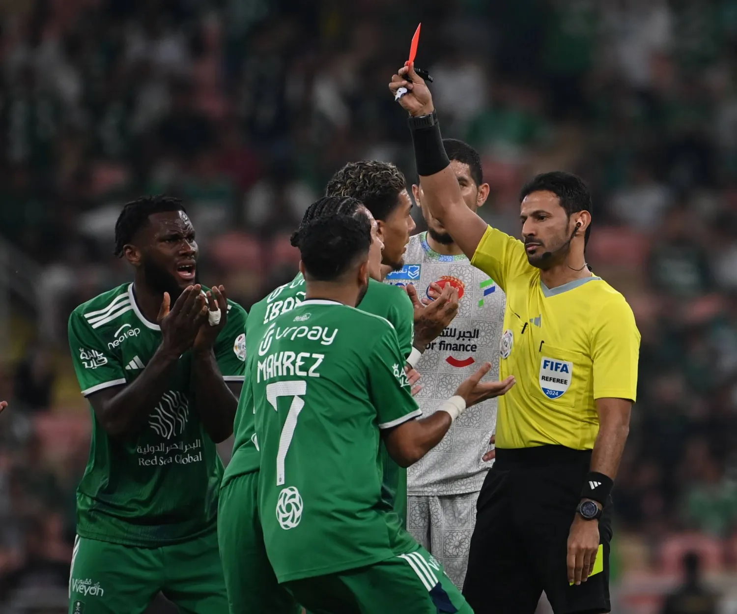 الحكم ماجد الشمراني يشهر «الحمراء» للاعب الأهلي إيبانيز (تصوير: علي خمج)