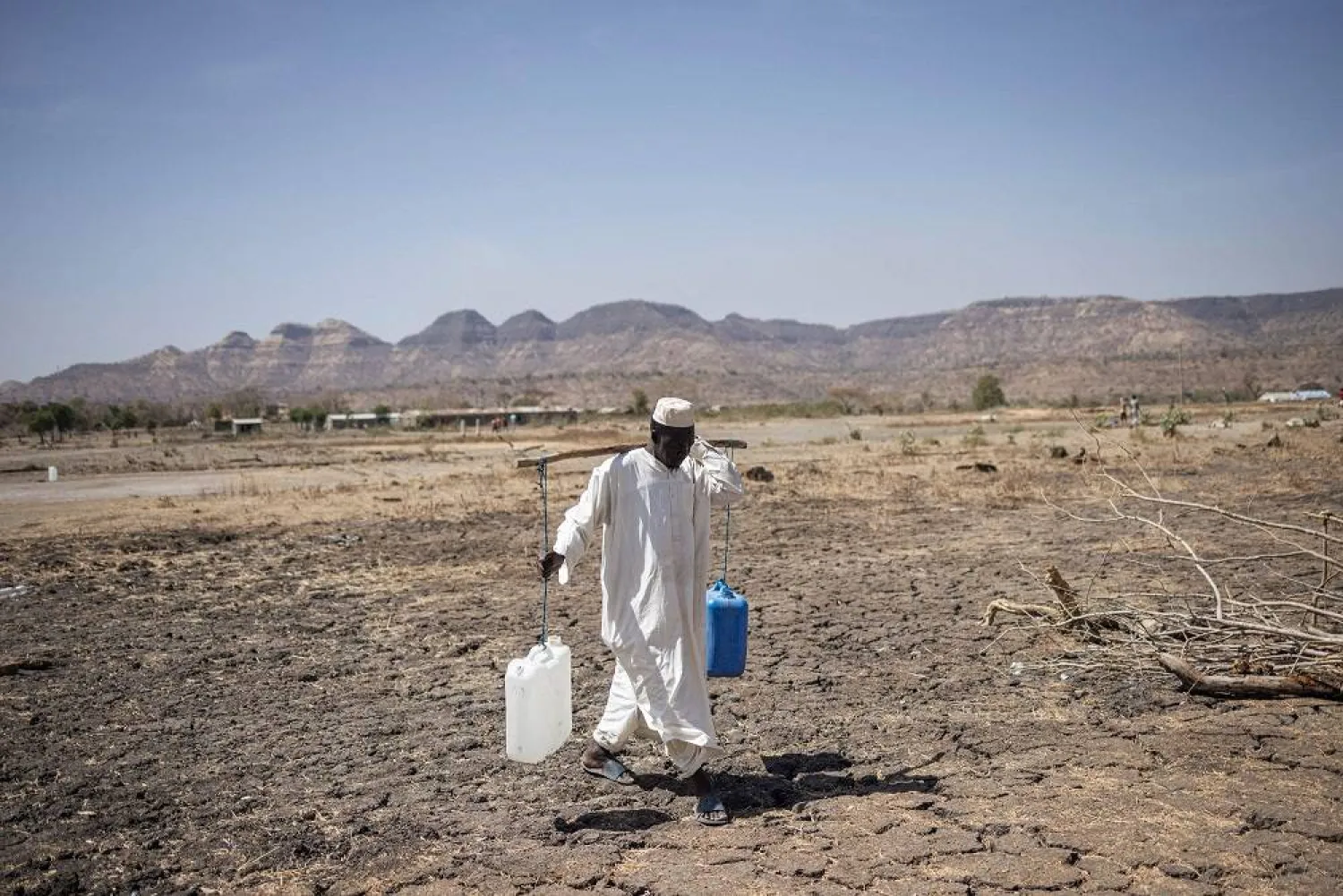 A Sudanese refugee walks back from collecting water in the newly established Awulala refugee camp, near Maganan, 80 km from the Sudanese border in Ethiopia's Amhara region, on February 28, 2024. (AFP)