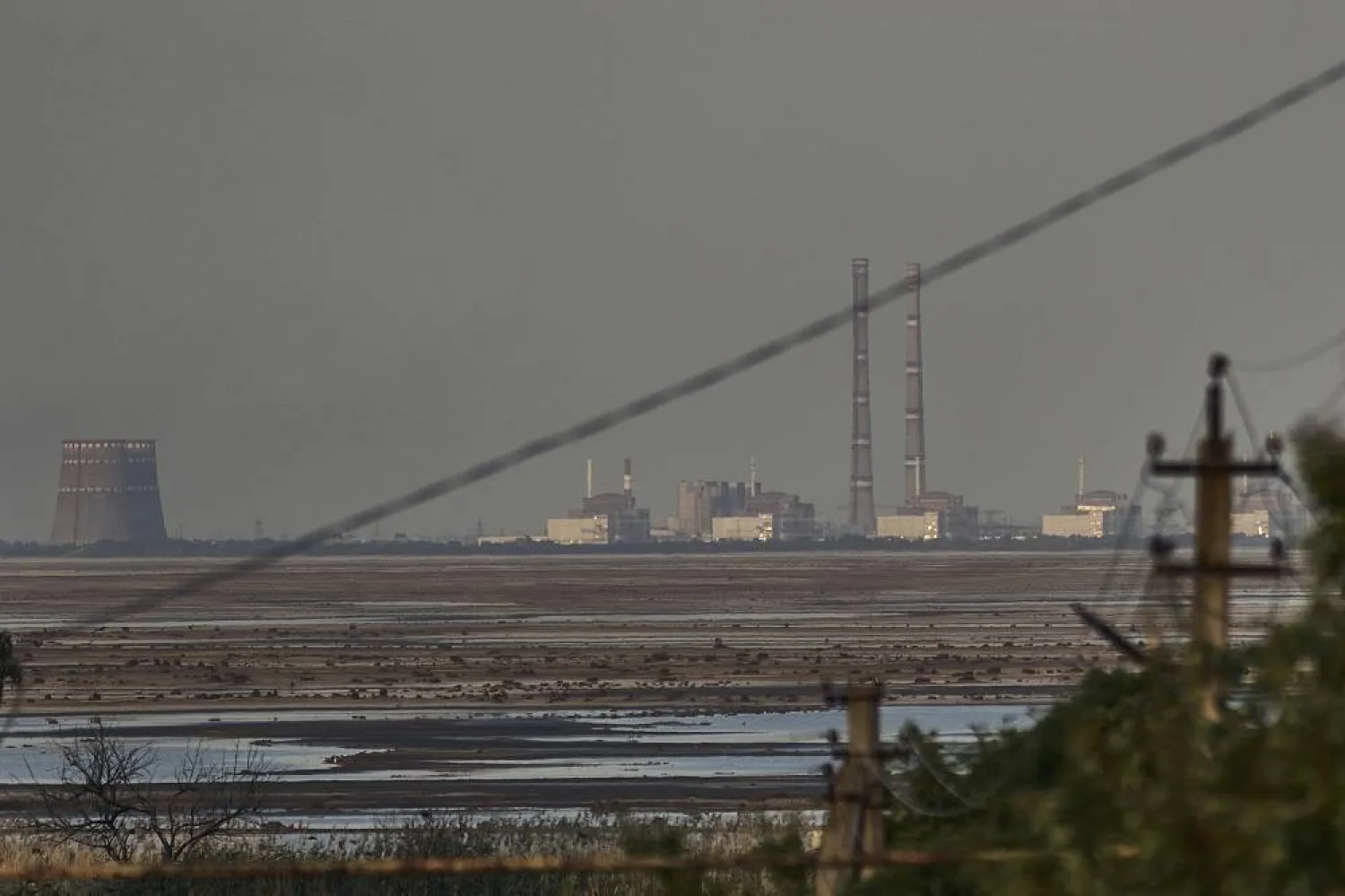 The Zaporizhzhia Nuclear Power Plant, Europe's largest, is seen in the background of the shallow Kakhovka Reservoir after the dam collapse, in Energodar, Russian-occupied Ukraine, Tuesday, June 27, 2023. (AP)