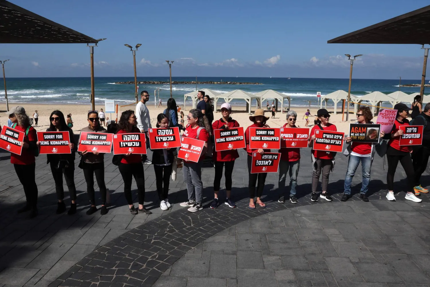 سلسلة بشرية في تل أبيب (الجمعة) بمناسبة يوم المرأة العالمي للمطالبة بإطلاق محتجزين إسرائيليين في قطاع غزة (أ.ف.ب)