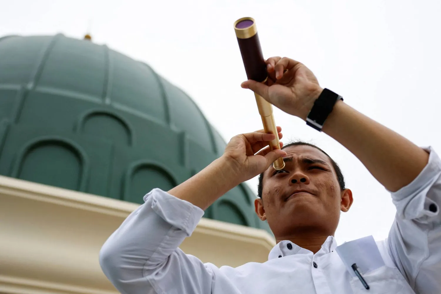 شاب إندونيسي يتحرى هلال شهر رمضان فوق سطح مسجد المسيارين في جاكارتا (رويترز)