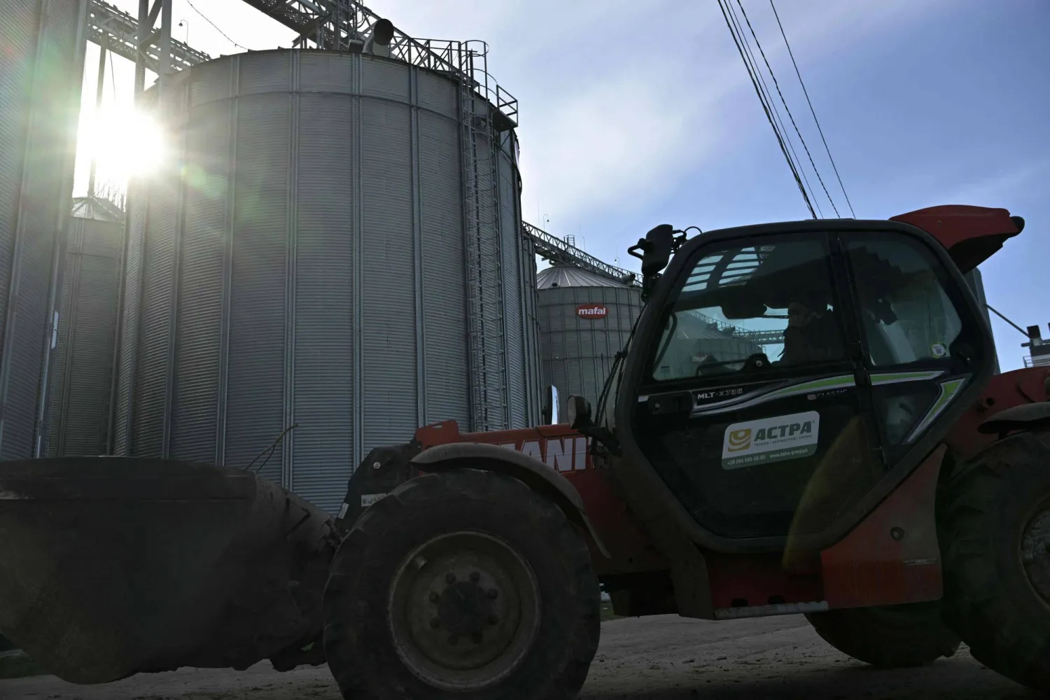 عامل يقود اللودر أمام صومعة حبوب في كييف 28 فبراير (شباط) 2024 (أ.ف.ب)