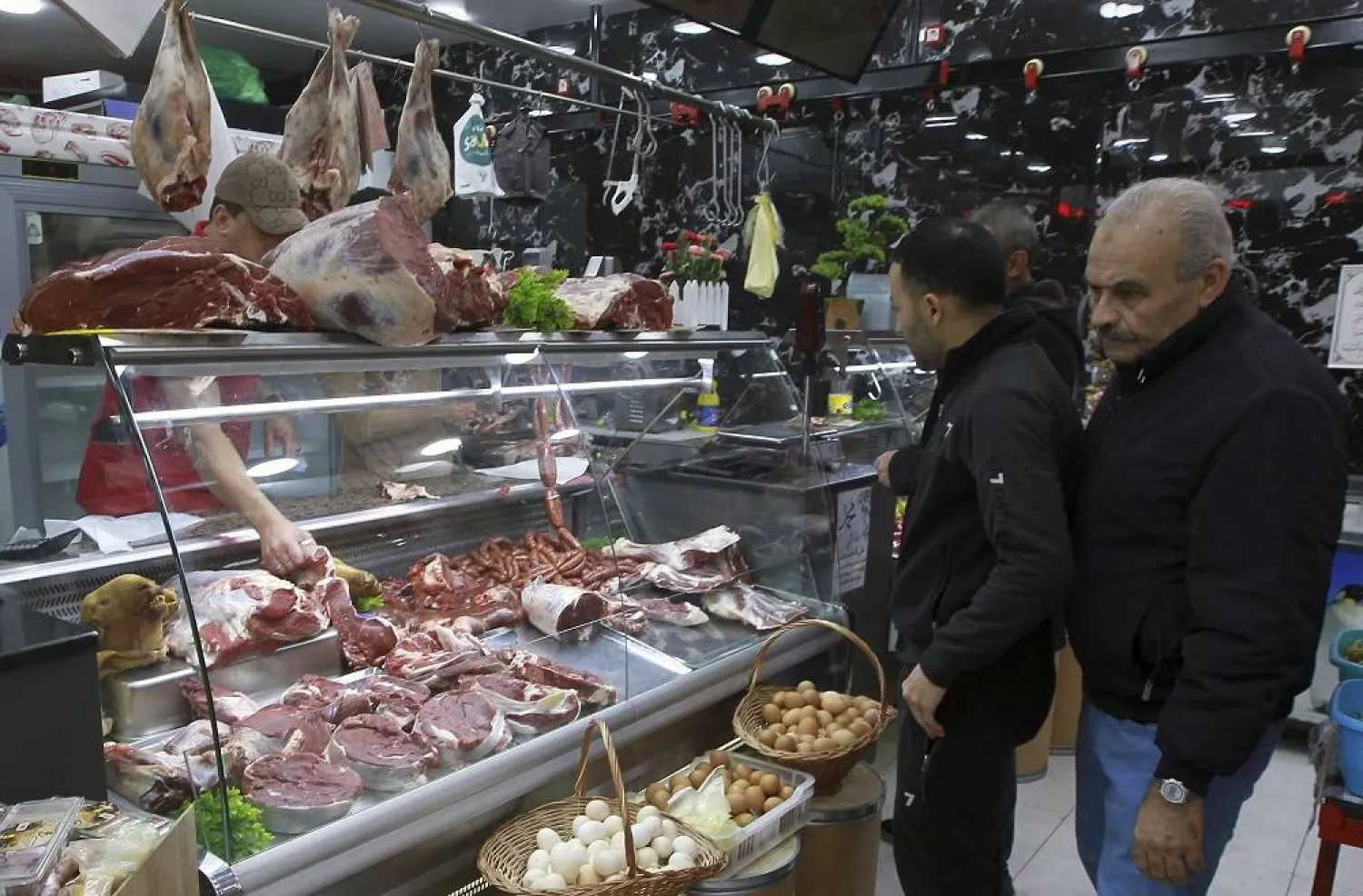 People shop for beef in a butchery in Algiers, Algeria, Sunday, Feb. 18, 2024. (AP)