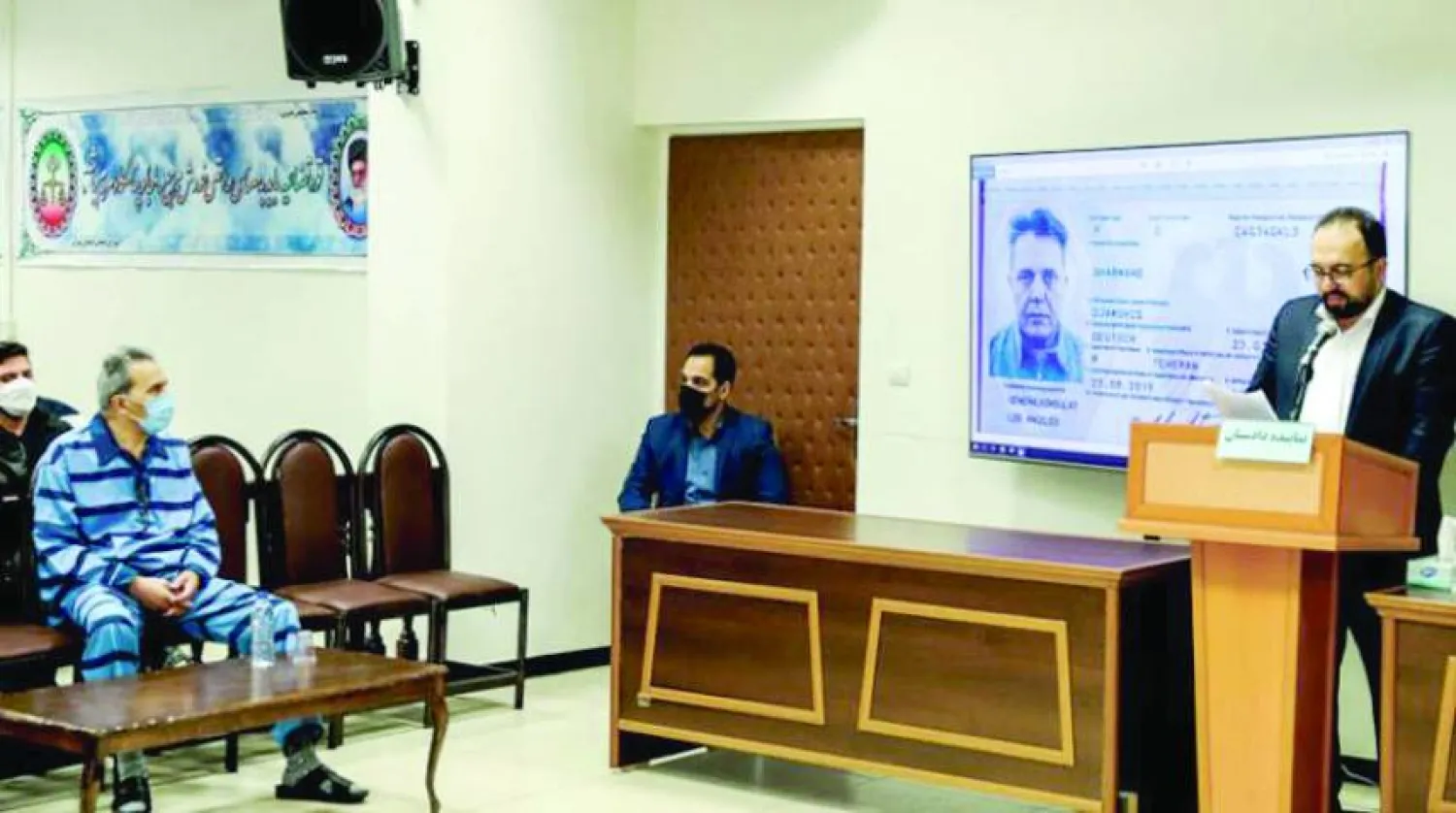 جمشيد شارمهد... في حين يُعرض جواز سفره الألماني على شاشة أثناء المحاكمة في فبراير 2022 (أ.ف.ب)