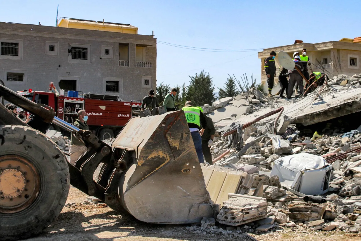 عمال إنقاذ يعملون على رفع الحطام إثر غارة جوية في سرعين (أ.ف.ب)