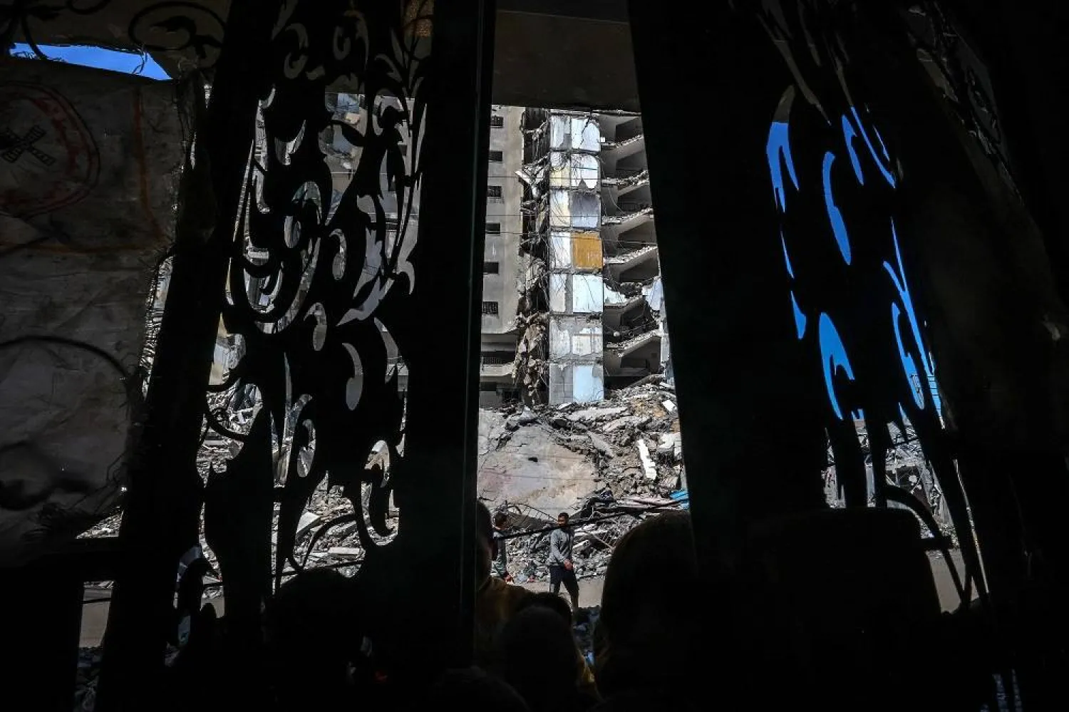 Palestinians walk past the rubble of a building destroyed in Israeli bombardment in Rafah in the southern Gaza Strip on the second day of the Muslim holy fasting month of Ramadan on March 12, 2024, amid ongoing battles between Israel and Hamas. (AFP)