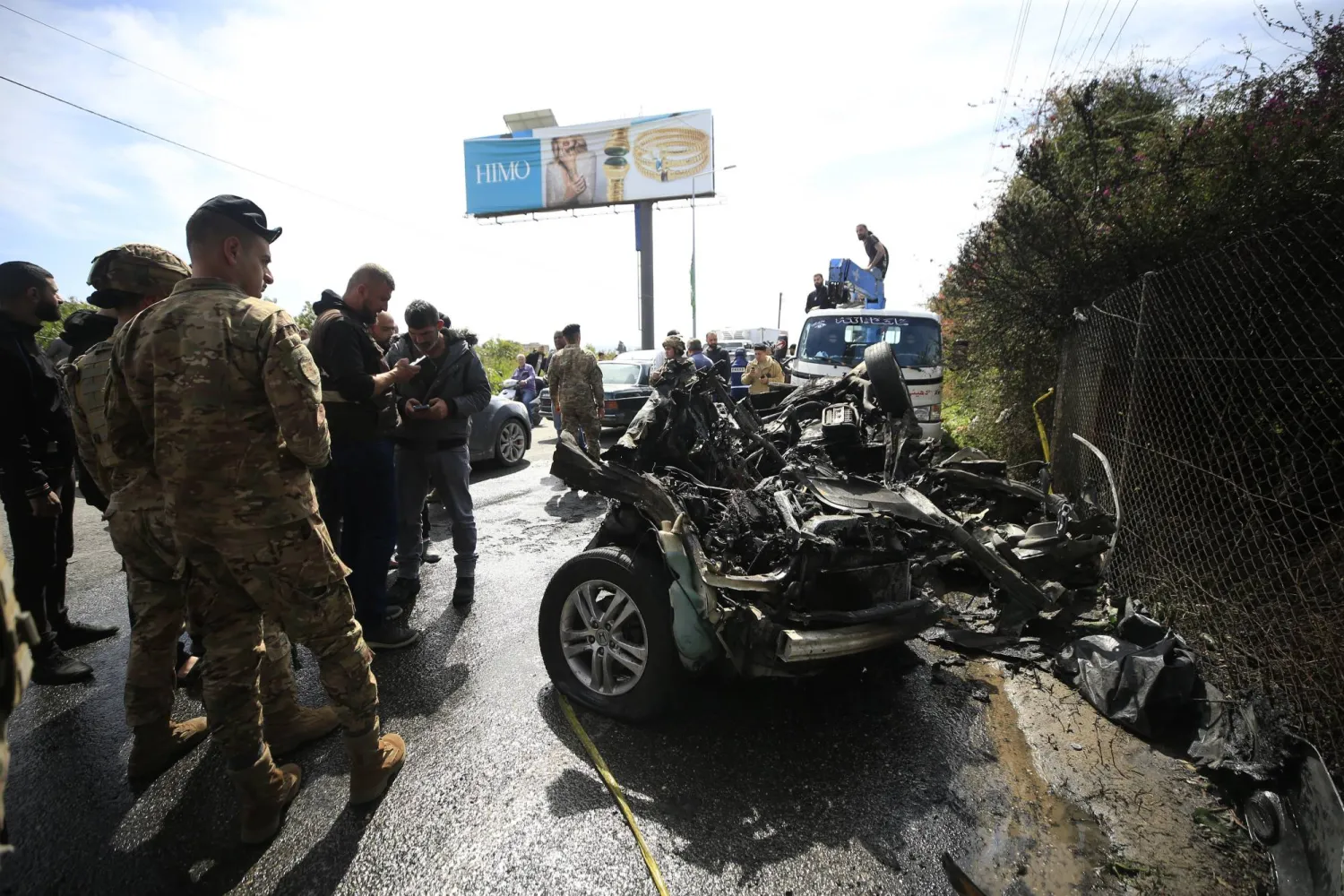 جنود في الجيش اللبناني يعاينون سيارةً استهدفتها مسيّرة إسرائيلية على طريق الحوش بالقرب من مدينة صور الساحلية (إ.ب.أ)