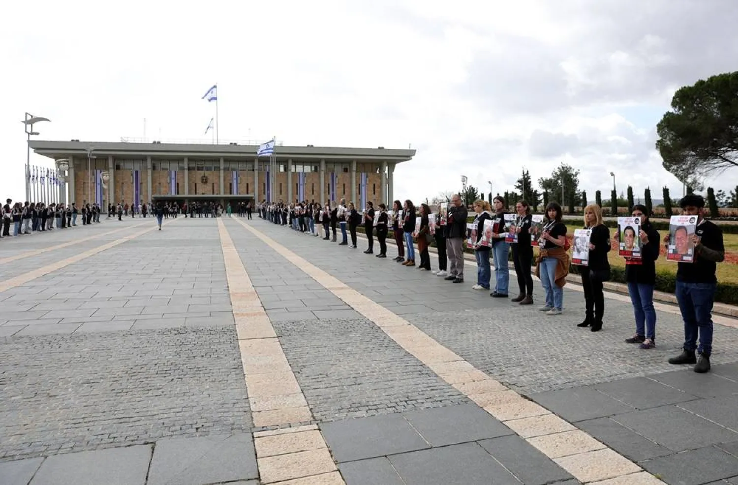 Family members of Israeli hostages held by Hamas in Gaza, carry pictures of their loved ones during a protest march marking 150 days of their captivity, calling for their immediate release, at the Knesset, the Israeli Parliament in Jerusalem, 04 March 2024. (EPA)