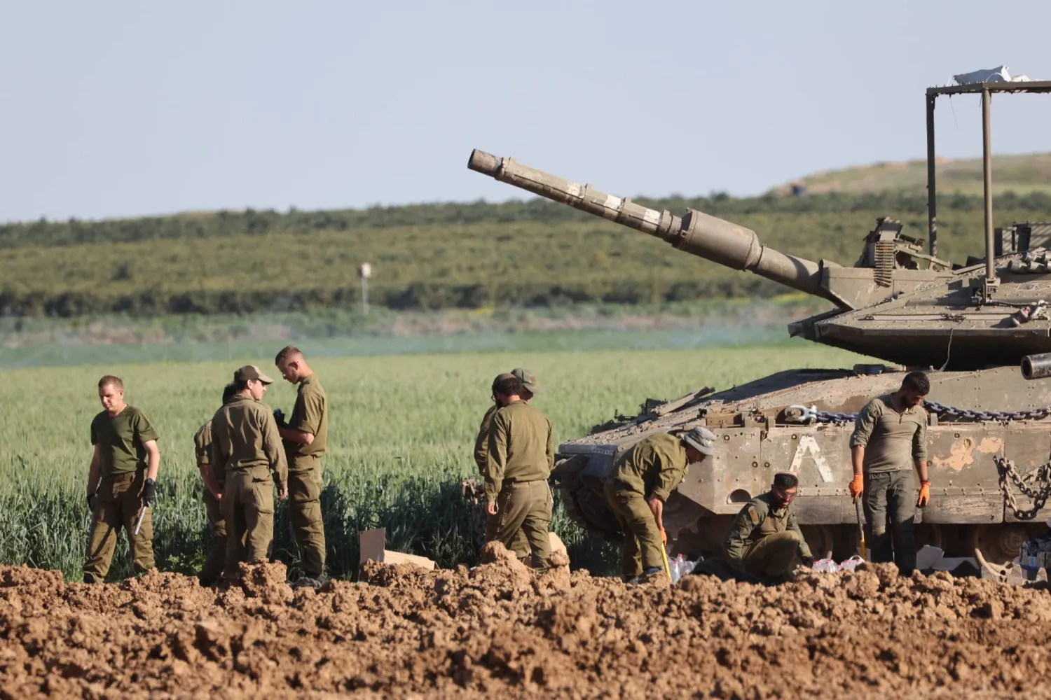 جنود إسرائيليون قرب دبابة عند الحدود مع قطاع غزة (إ.ب.أ)