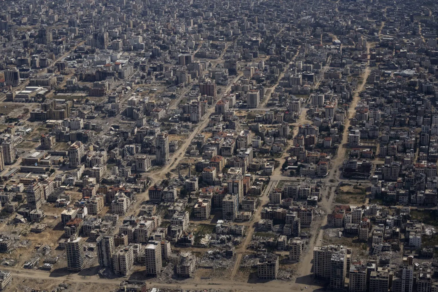 Destroyed buildings are seen through the window of an airplane from the US Air Force overflying the Gaza Strip, Thursday, March 14, 2024. (AP Photo/Leo Correa)