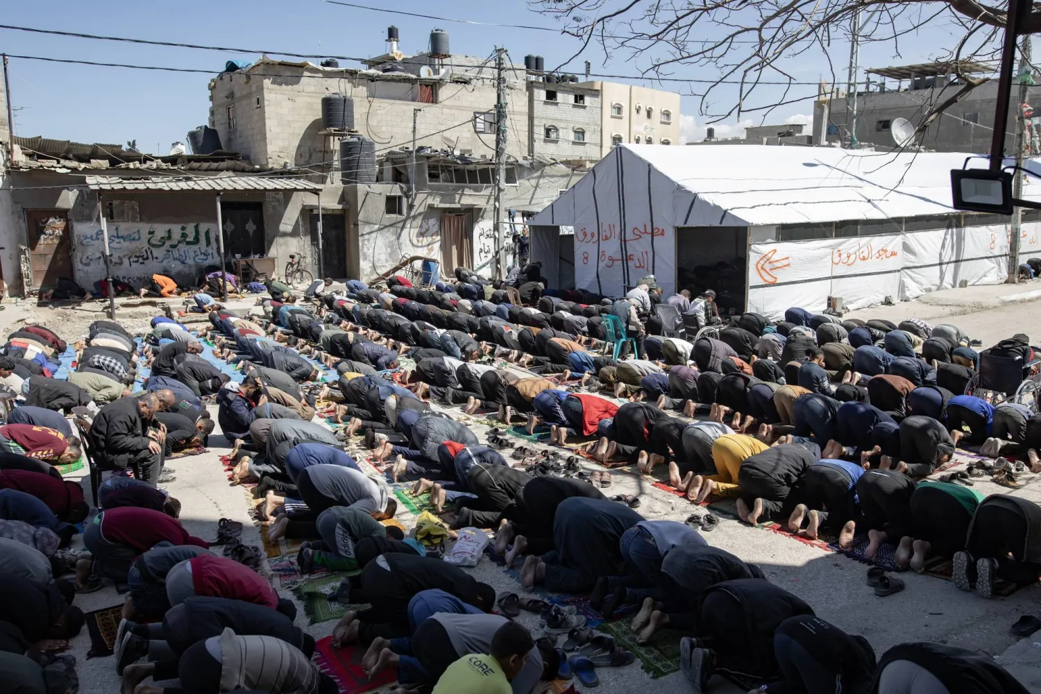 فلسطينيون يؤدون صلاة الجمعة الأولى بجوار أنقاض مسجد دمرته غارة إسرائيلية في وقت سابق برفح جنوب قطاع غزة 15 مارس 2024 (وكالة حماية البيئة)