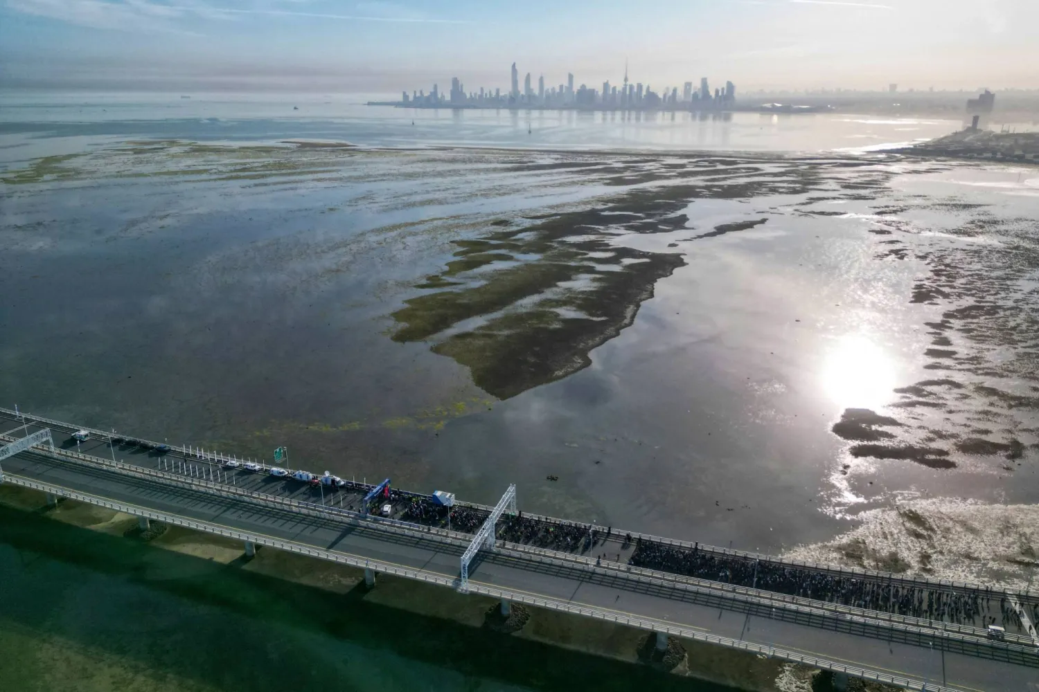 In this aerial view, people take part in the first edition of the Kuwait Sports Day marathon, along the Sheikh Jaber al-Ahmad al-Sabah Causeway in Kuwait City on March 9, 2024. (Photo by YASSER AL-ZAYYAT / AFP)