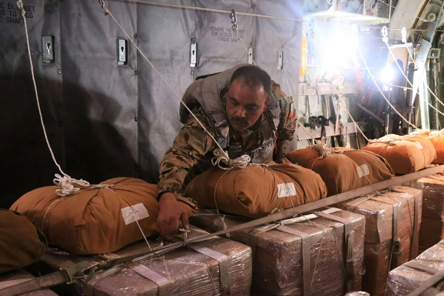 This handout picture released by the Jordanian army on March 16, 2024, shows members of the Jordanian army aboard a German military aircraft preparing humanitarian aid parcels before an airdrop mission over the northern Gaza Strip. (Photo by Jordanian army / AFP)