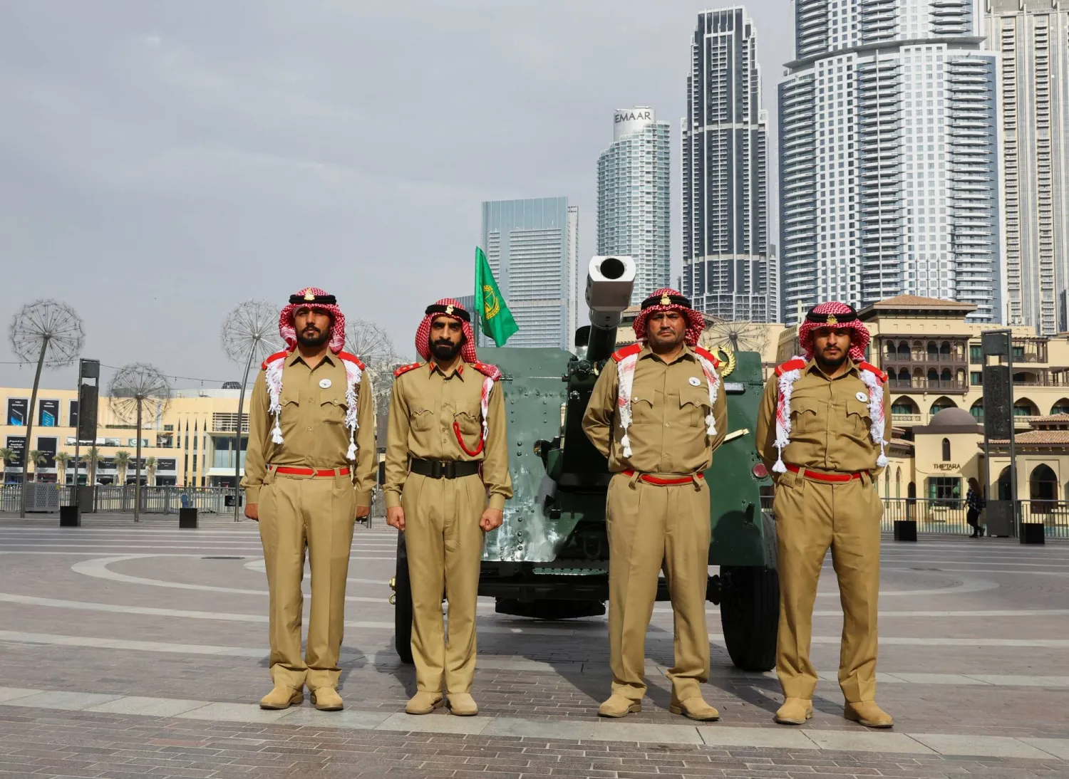 Dubai police officers pose for a photo before firing the canon outside Dubai Mall during the holy month of Ramadan, in Dubai, United Arab Emirates, March 15, 2024. REUTERS/Rula Rouhana