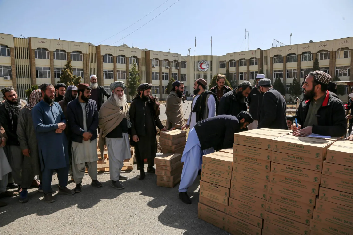 أفغان يتلقون مساعدات مقدمة من مركز الملك سلمان للإغاثة والأعمال الإنسانية في المملكة العربية السعودية للمحتاجين خلال شهر رمضان المبارك في كابول (إ.ب.أ)