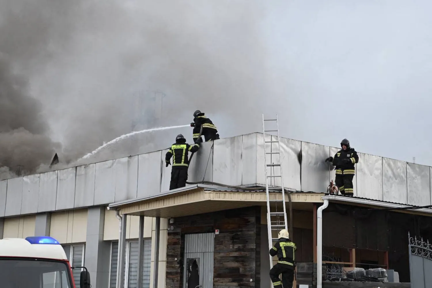 رجال الإطفاء يحاولون إخماد حريق على سطح مبنى أصيب بالقصف في بيلغورود الروسية القريبة من الحدود مع أوكرانيا الأحد (رويترز)