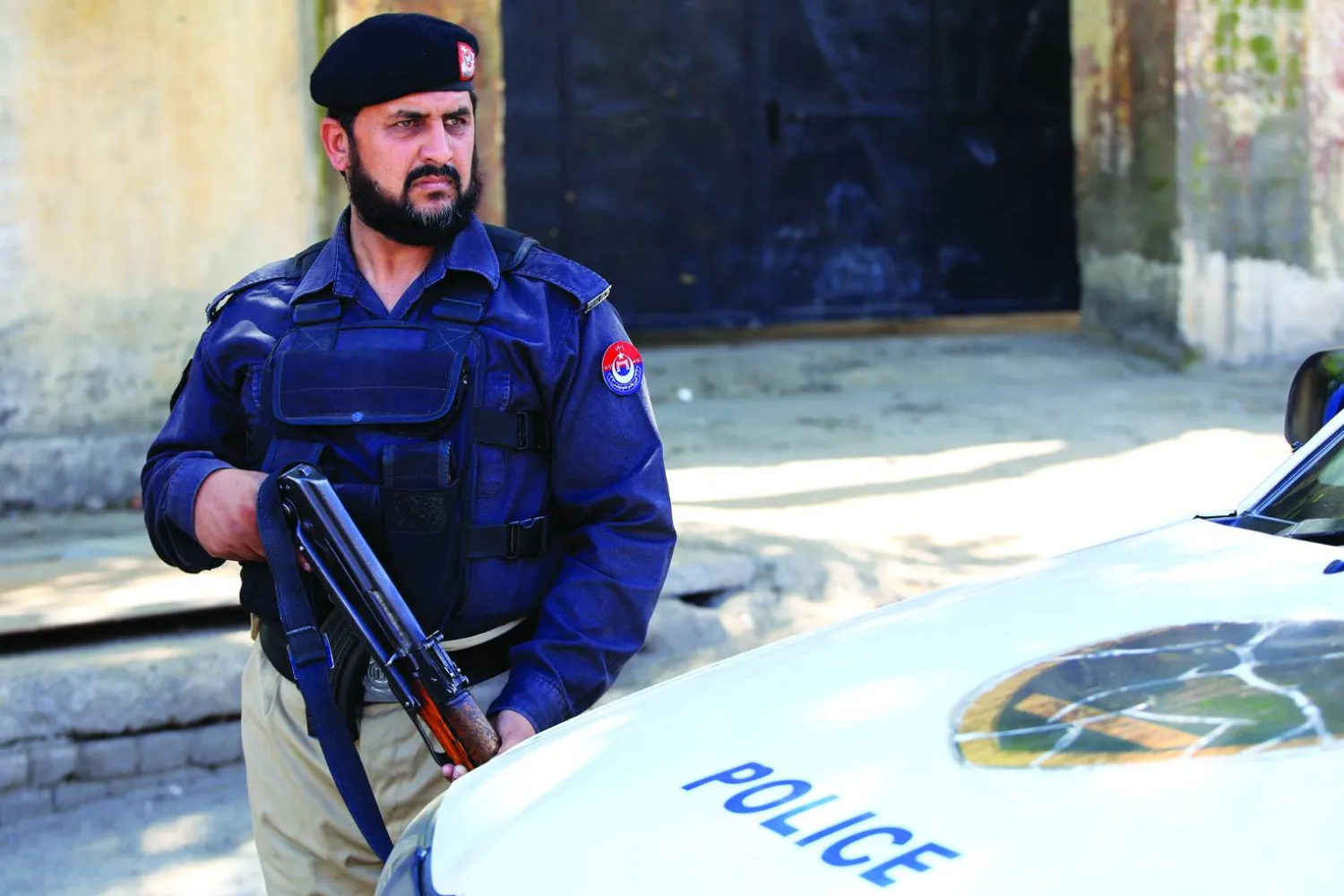 مسؤول أمني باكستاني يقف حارساً عند نقطة تفتيش في بيشاور عاصمة مقاطعة خيبر بخوا بباكستان في 18 مارس 2024 وقالت حكومة «طالبان» إن طائرات مقاتلة باكستانية قصفت قرى أفغانية عدة (إ.ب.أ)