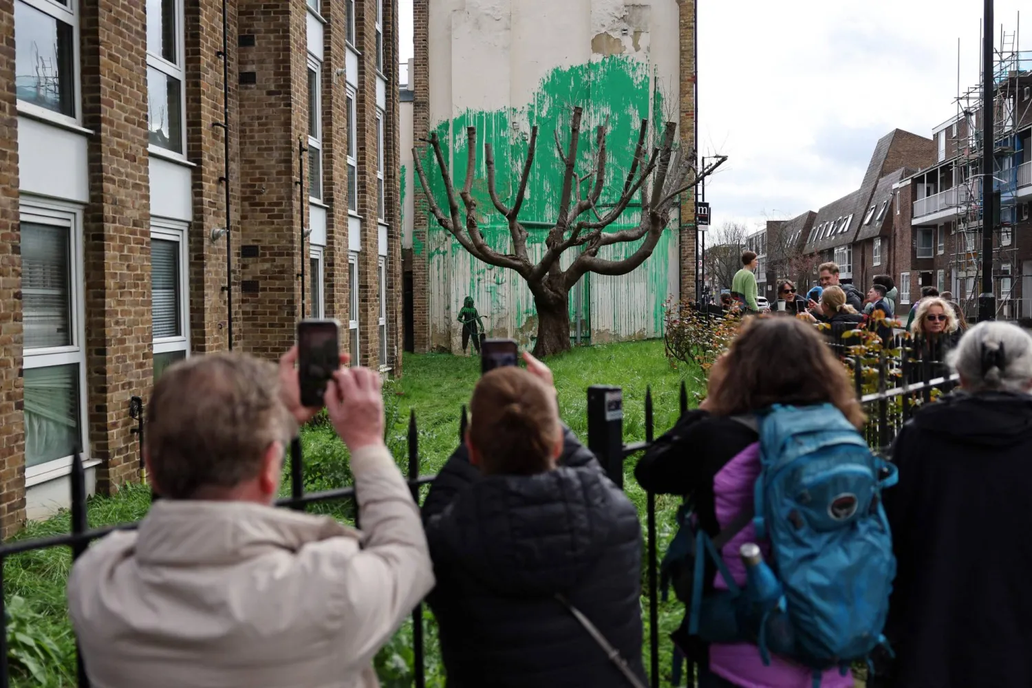 Crowds gather to view a Banksy artwork near Finsbury Park in north London on March 18, 2024. (Photo by Adrian DENNIS / AFP) 