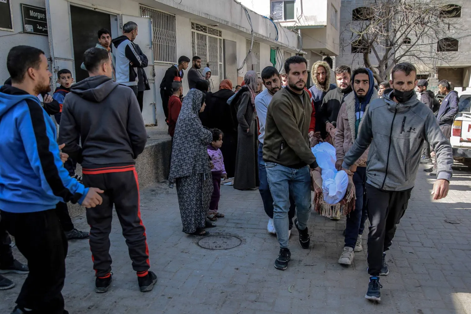 فلسطينيون ينقلون جثمان رجل قُتل في القصف الإسرائيلي من مشرحة مستشفى الشفاء بمدينة غزة (أ.ف.ب)