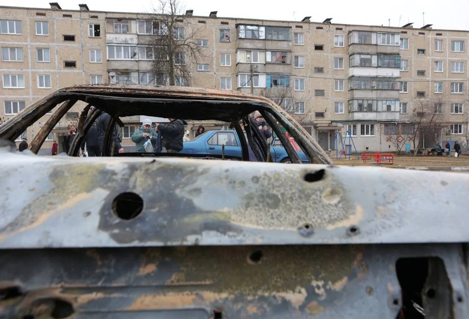  Local residents gather next to damaged cars hit by shelling, what local authorities called a Ukrainian military strike, in the course of the Russia-Ukraine conflict in the settlement of Razumnoe in the Belgorod Region, Russia March 19, 2024. (Reuters)
