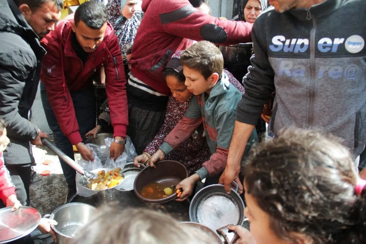  Palestinians gather to receive free food as Gaza residents face crisis levels of hunger, during the holy month of Ramadan, amid the ongoing conflict between Israel and Hamas, in Jabalia in the northern Gaza Strip March 19, 2024. (Reuters)