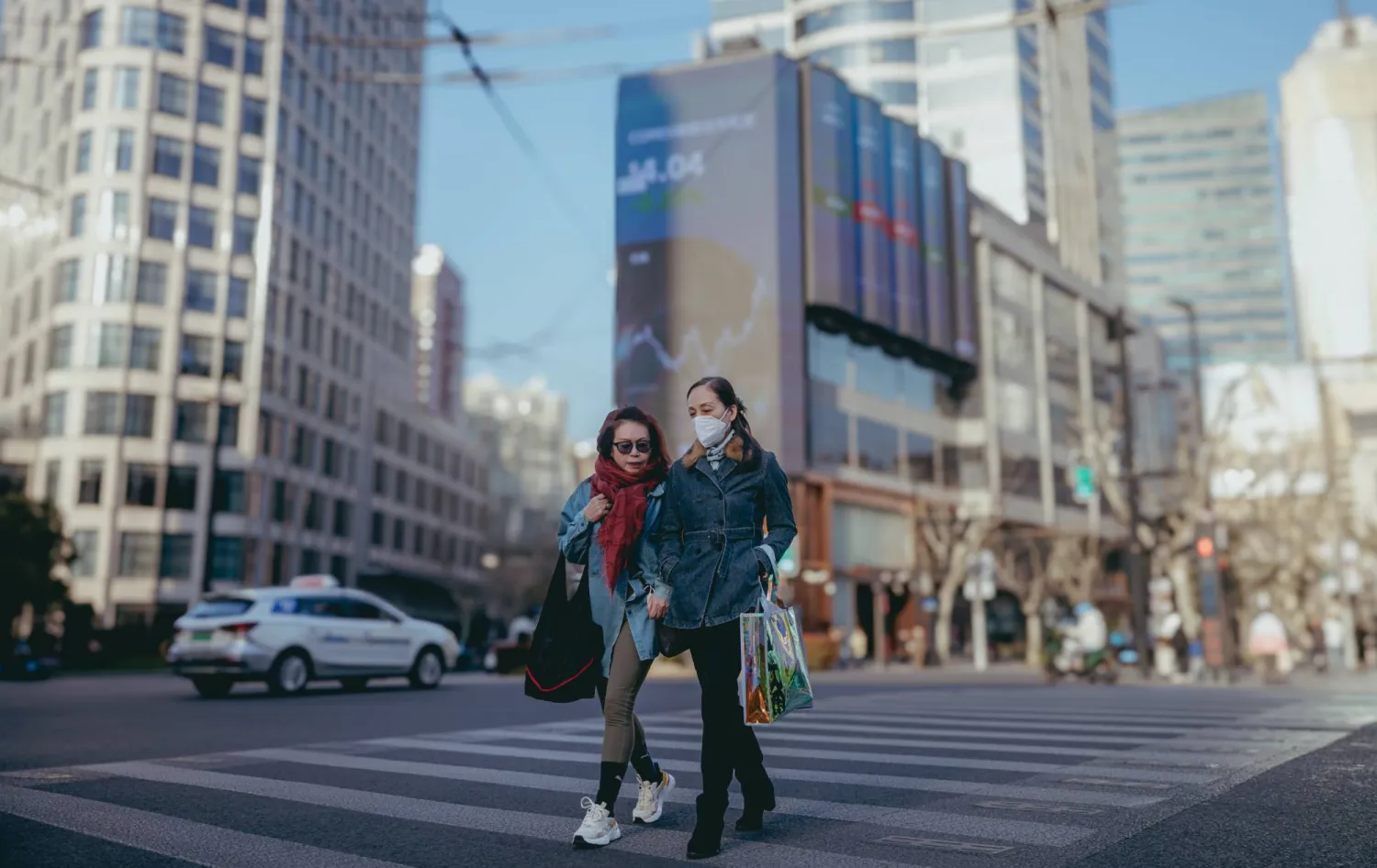 مشاة يعبرون الطريق في مدينة شنغهاي الصينية (إ.ب.أ)